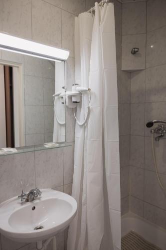 a bathroom with a sink and a shower with a mirror at Motelis Gariūnai in Vilnius