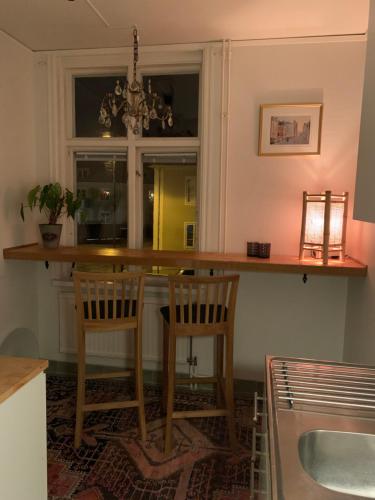a kitchen with a bar with chairs and a sink at Stensö Room in Kalmar
