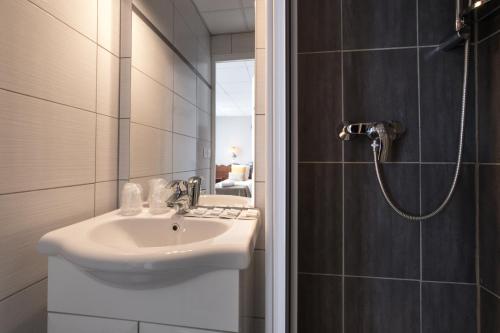 a bathroom with a sink and a shower at Hôtel Les Essarts, USSIM Vacances in Valloire