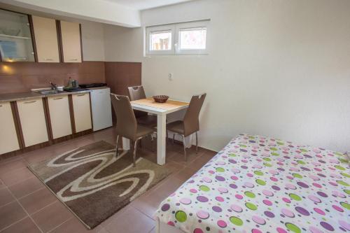 a small kitchen with a table and chairs in a room at Apartments Dedeic in Žabljak