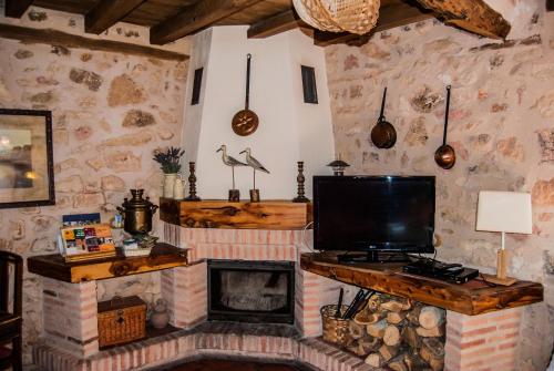 a living room with a tv and a fireplace at La Fuente del Poval in Caballar