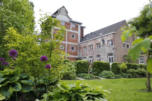 a garden in front of a large brick building at Housing De Brouwerij in Westdorpe