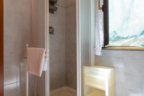 a bathroom with a shower with a toilet and a window at Appartamento Le Ginestre in Rio nellʼElba