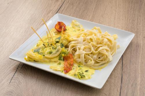 a plate of food with pasta on a table at Hôtel Les Essarts, USSIM Vacances in Valloire