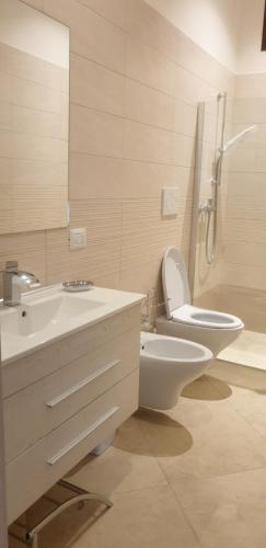 a bathroom with a toilet and a sink at White Stone in Fasano