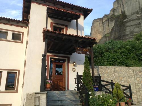 a house with a staircase in front of a mountain at Pyrgos Adrachti in Kalabaka