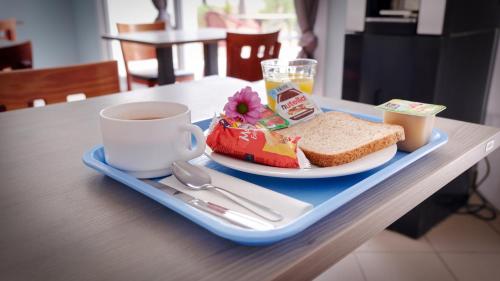 a tray with a plate of food and a cup of coffee at Kyriad Direct Perpignan Nord - Aéroport in Rivesaltes