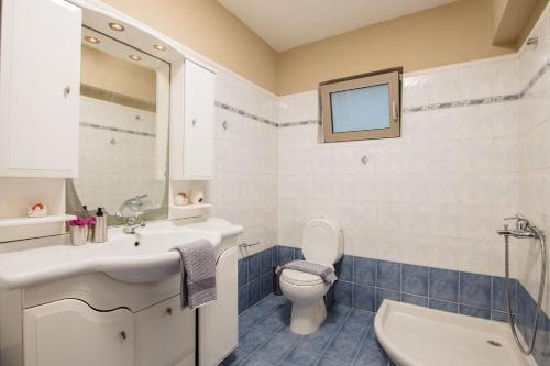 a bathroom with a white sink and a toilet at Villa Paradise in Laganas