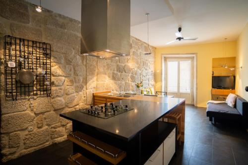 a kitchen with a counter top and a stone wall at RIBEIRA by YoursPorto in Porto