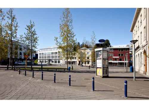 a street with blue poles in a city with buildings at Torg Guest House in Akureyri