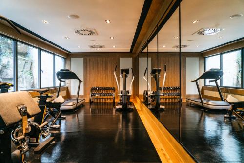 a gym with a row of exercise bikes and mirrors at Vincci Ponte de Ferro in Vila Nova de Gaia