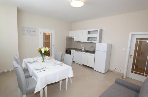 a dining room with a table and chairs and a kitchen at Rezidence U prince č.3 in Jičín