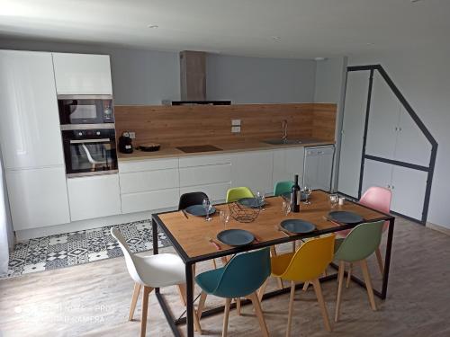 une cuisine avec une table et des chaises en bois dans l'établissement Maison de village 6/9 prs, à Sauveterre-de-Rouergue