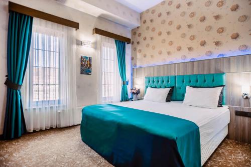 um quarto com uma cama grande e uma cabeceira azul em Highway Otel em Elmalık
