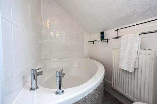 a white bathroom with a tub and a sink at Cosy 2 Bed Apartment - Close to Leeds Centre in Moortown