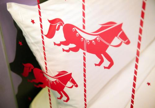 a red horse applique on a white pillow at NL Concept Hotel in Kaohsiung