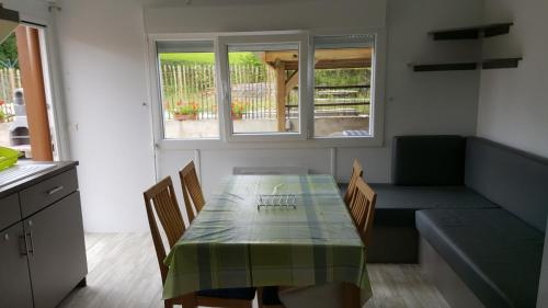 une salle à manger avec une table et un canapé dans l'établissement Mobile-home, à Braucourt