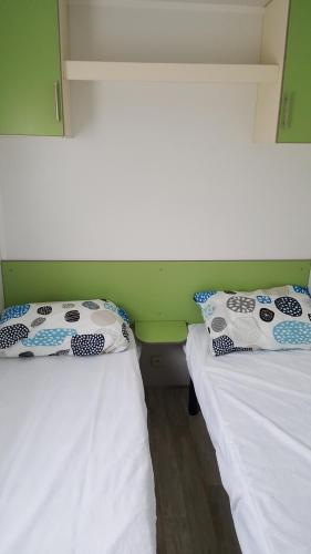 2 letti singoli in una camera con pareti verdi di Mobile-home a Braucourt