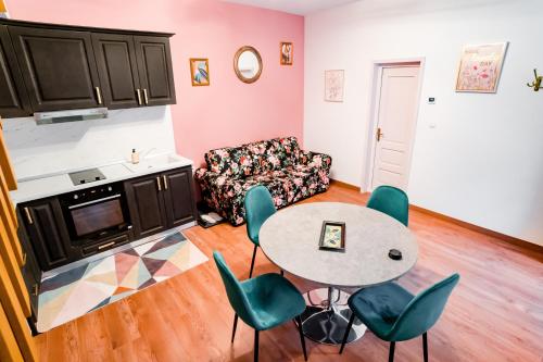 uma sala de estar com uma mesa e cadeiras e um sofá em Galeria Grafit Apartments em Sibiu