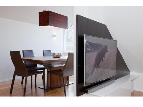 a living room with a television and a dining room table at Torg Guest House in Akureyri