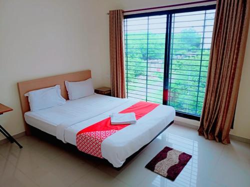 a bedroom with a bed and a large window at Hotel Relax Inn in Nagpur