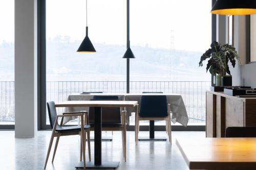 une salle à manger avec une table et des chaises blanches dans l'établissement Stilla Ristorante e Camere, à Colognola ai Colli
