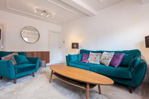 a living room with a green couch and a table at Cosy 2 Bed Apartment - Close to Leeds Centre in Moortown