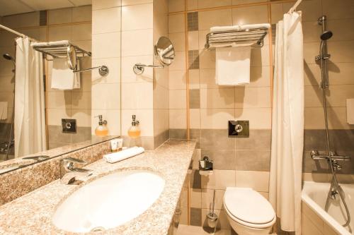 uma casa de banho com um lavatório e um WC em Monika Centrum Hotels em Riga