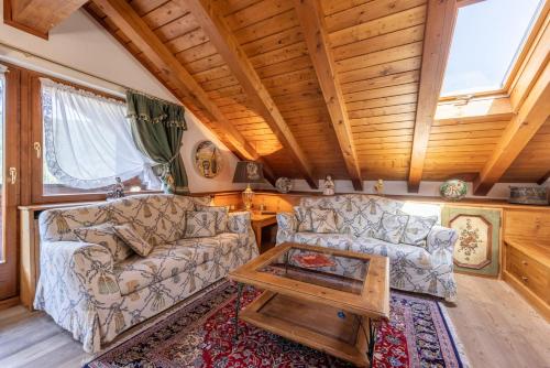 a living room with a couch and a coffee table at Mansarda Belvedere - panoramica e wellness in San Vito di Cadore