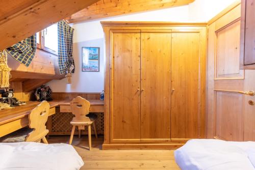 a bedroom with a bed and a desk in a room at Mansarda Belvedere - panoramica e wellness in San Vito di Cadore