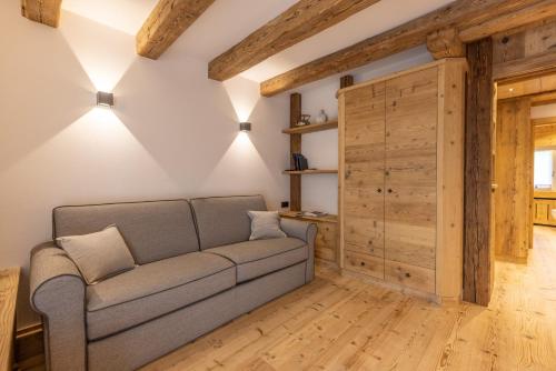 a living room with a couch and a wooden door at Lino Deluxe Suite in Borca di Cadore