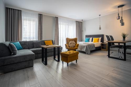 a living room with a couch and a table and chairs at Apartamenty na Chrobrego in Bydgoszcz