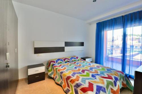 um quarto com uma cama colorida e uma janela em Apartment Nati em Lloret de Mar