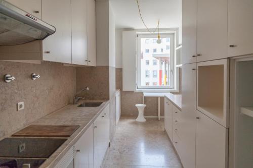 eine Küche mit weißen Schränken und einem Fenster in der Unterkunft Classy 2BDR Apartment in Downtown by LovelyStay in Lissabon