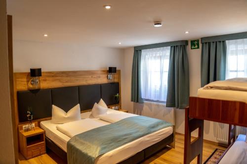 a bedroom with two beds and a large window at Hotel Am Siebersturm in Rothenburg ob der Tauber