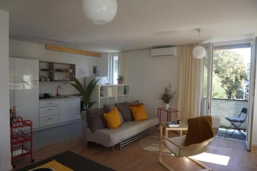 a living room with a couch and a kitchen at Central sunny sweet spot in Varaždin