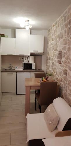 a kitchen with white cabinets and a table in a room at Antea in Split
