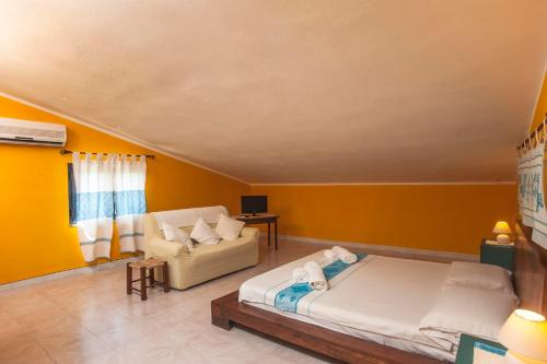 a living room with a bed and a couch at Mansarda Marina in Villa San Pietro