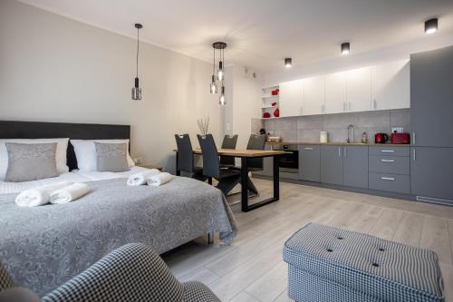 Un dormitorio con una cama y una mesa y una cocina. en Apartamenty na Chrobrego, en Bydgoszcz