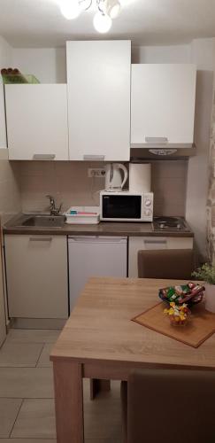 a kitchen with white cabinets and a table with a microwave at Antea in Split