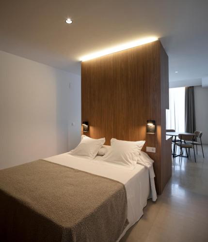 a bedroom with a large bed with white sheets at Mon Suites Dau in Valencia