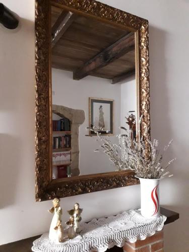 uno specchio a parete in una stanza con tavolo di Casa Profumo d' Estate a Pitigliano