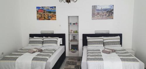 Dos camas una al lado de la otra en un dormitorio. en Ferhadija A&E Apartment Sarajevo, en Sarajevo