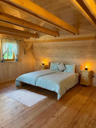ein Schlafzimmer mit einem Bett in einem Holzhaus in der Unterkunft Roubenka Vlčí Hora in Krásná Lípa