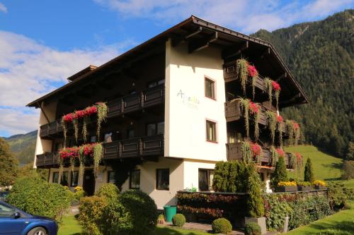 un bâtiment avec des fleurs sur son côté dans l'établissement Apart-Garni Alpevita, à Mayrhofen