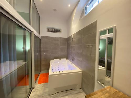 a bathroom with a tub and a sink and a shower at Wellkhome Appartements & Services in Bordeaux