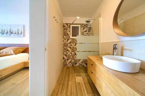 une salle de bain avec un lavabo, un lit et un miroir dans l'établissement Villa Zala, à Rasopasno