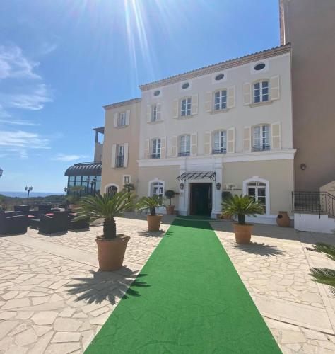 a building with a green lawn in front of it at Le Fregate Provence in Bandol