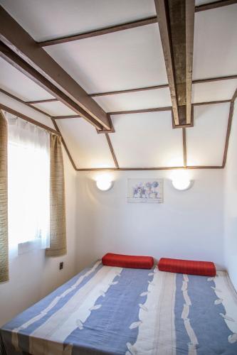 a bed in a room with a ceiling at Aranysellő Vendégház in Abádszalók