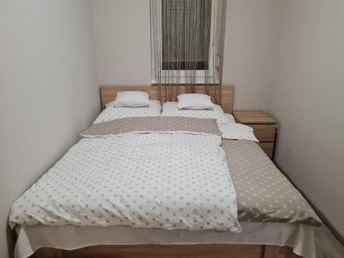 een bed met twee kussens in een slaapkamer bij Siófok Sophia Apartman in Siófok